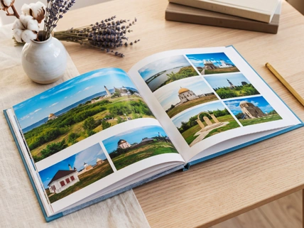 Открытая полиграфическая фотокнига серии Стандарт на столе, демонстрирующая высокое качество цифровой печати и яркую, контрастную цветопередачу пейзажных снимков